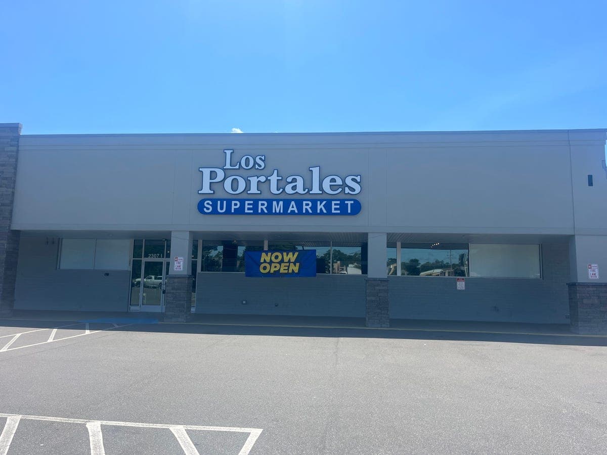 Los Portales Supermarket storefront exterior with "Now Open" banner